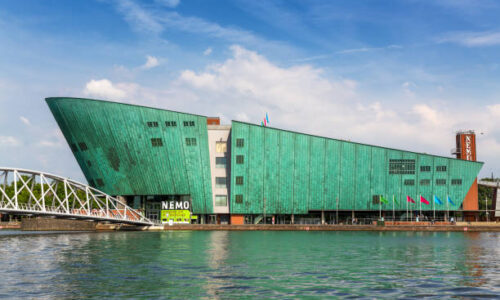 istockphoto-1320155902-612x612 Amsterdam, Netherlands - 7th July 2014: The Nemo Science Museum on the waterfront and located in the Oosterdokseiland neighbourhood. Designed by Renzo Piano and opened in 1997.