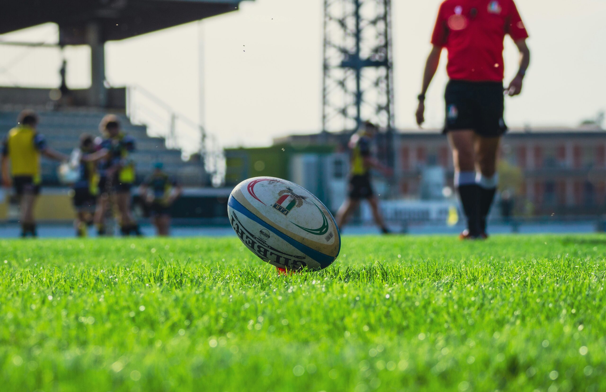 davide-buttani-UKWHDxGuQ0k-unsplash Rugby ball on a pitch